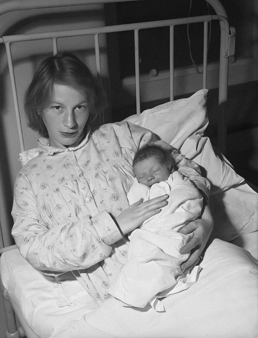 a woman holding a baby in a hospital bed