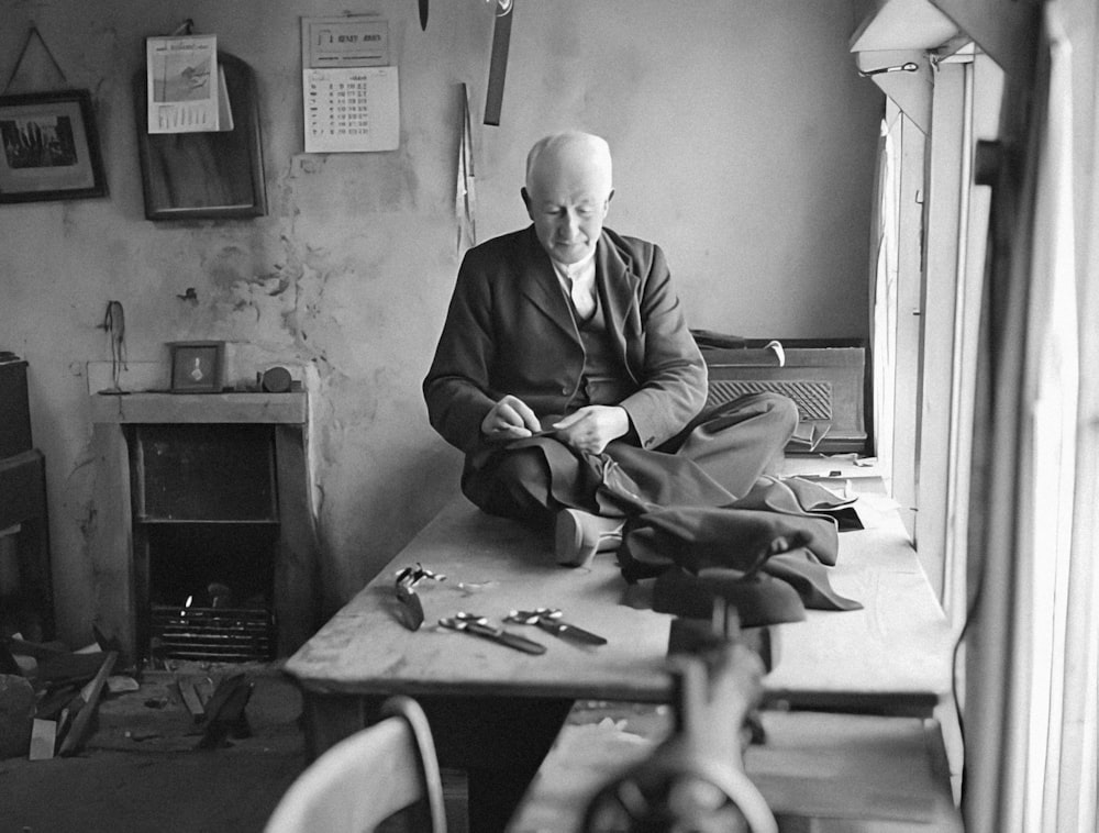 a man sitting at a table with a pair of scissors