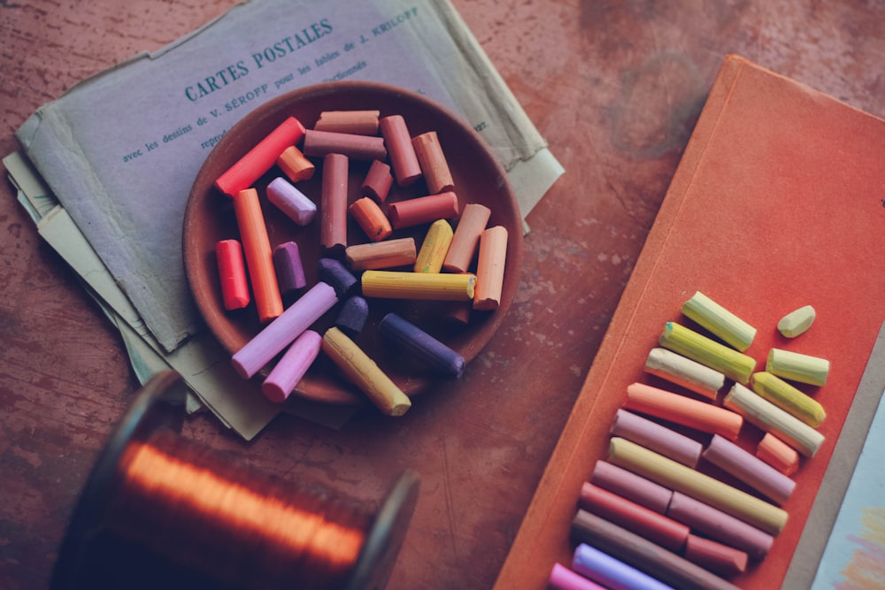 a bowl of crayons next to a pair of scissors