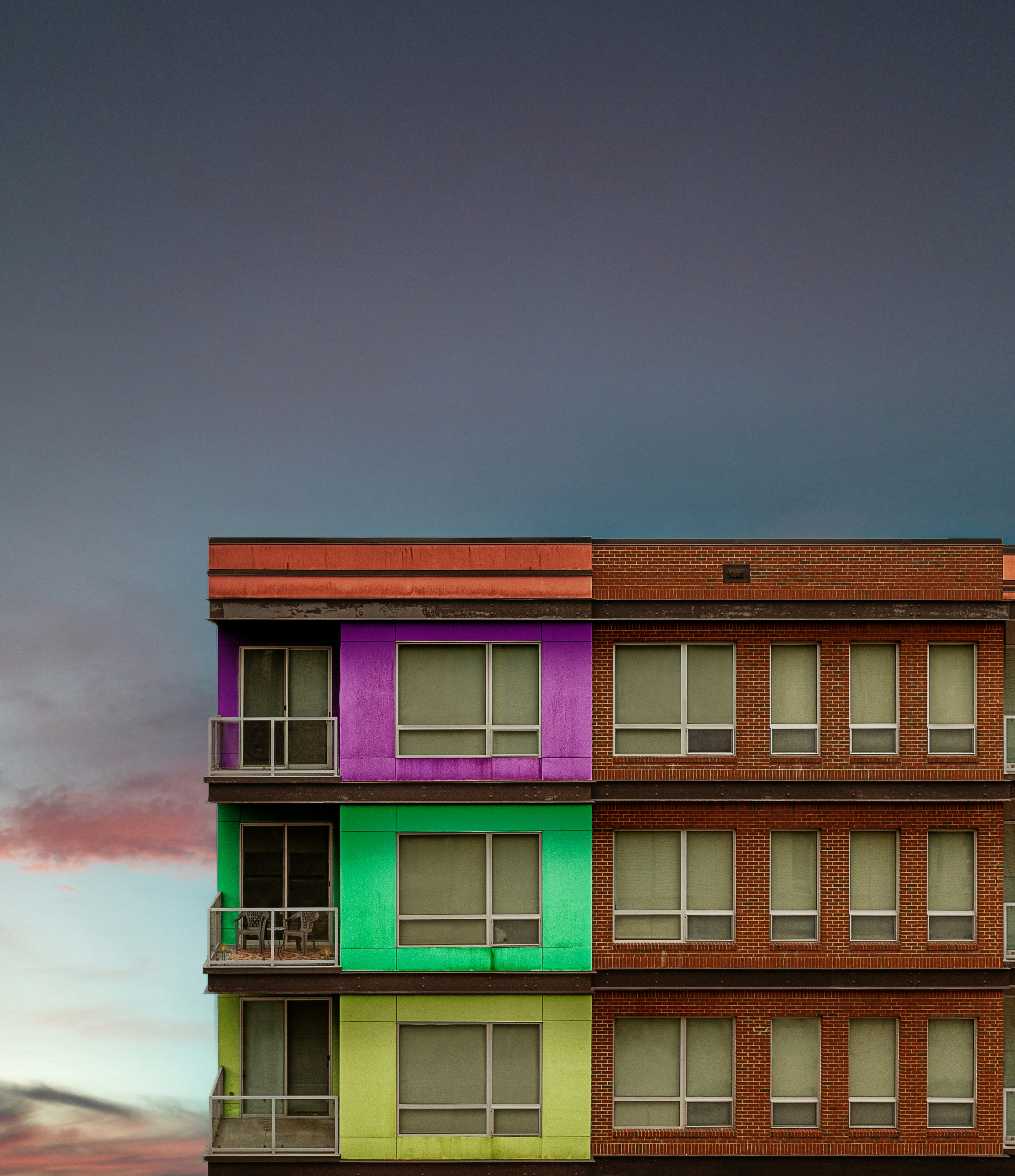 Un edificio multicolor con una torre del reloj al fondo