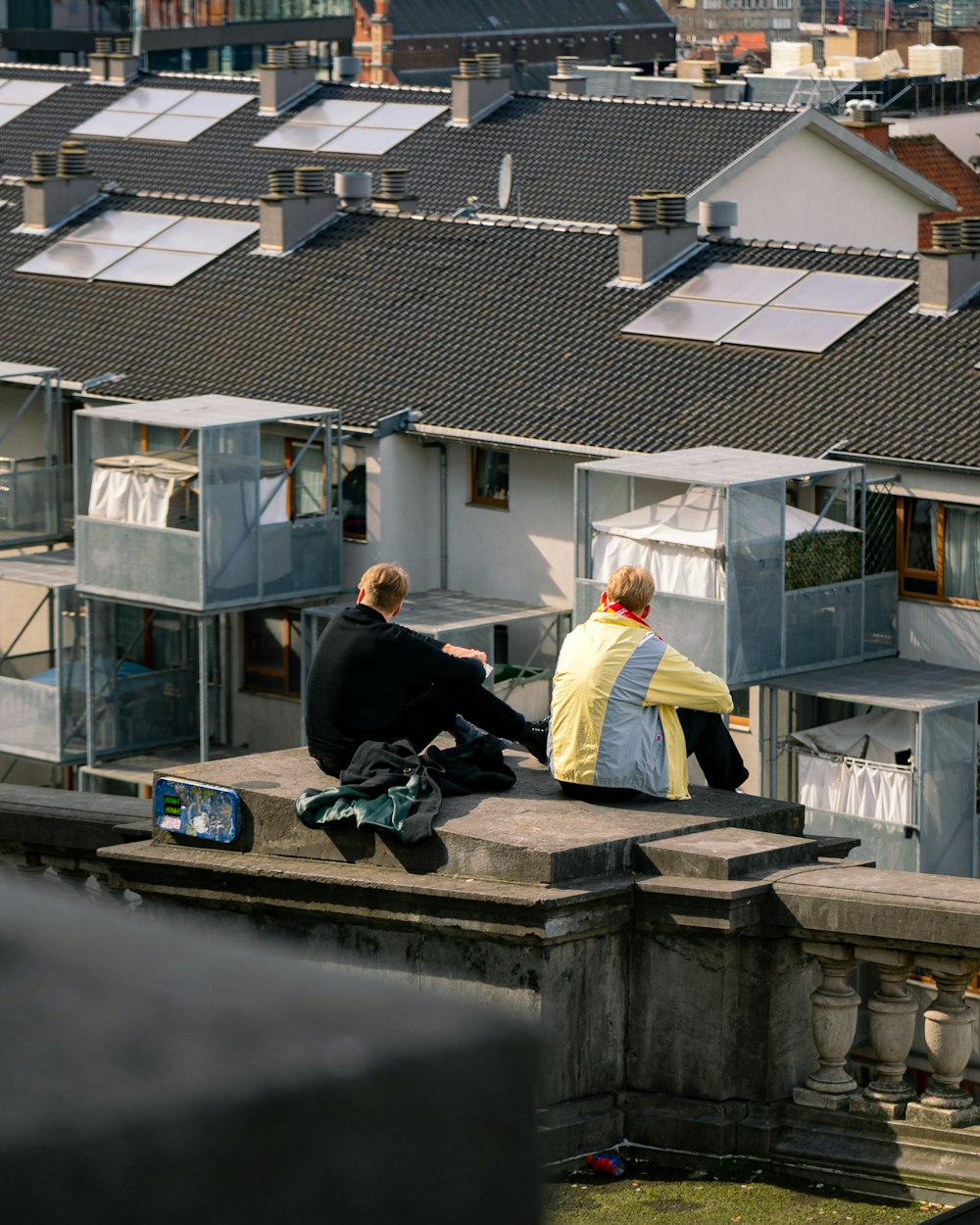 a couple of people sitting on top of a roof