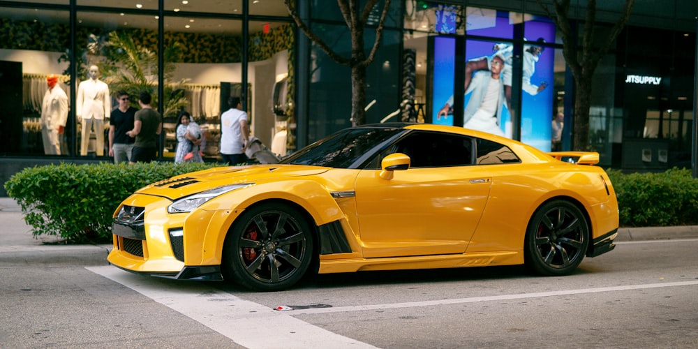 a yellow sports car parked in front of a building