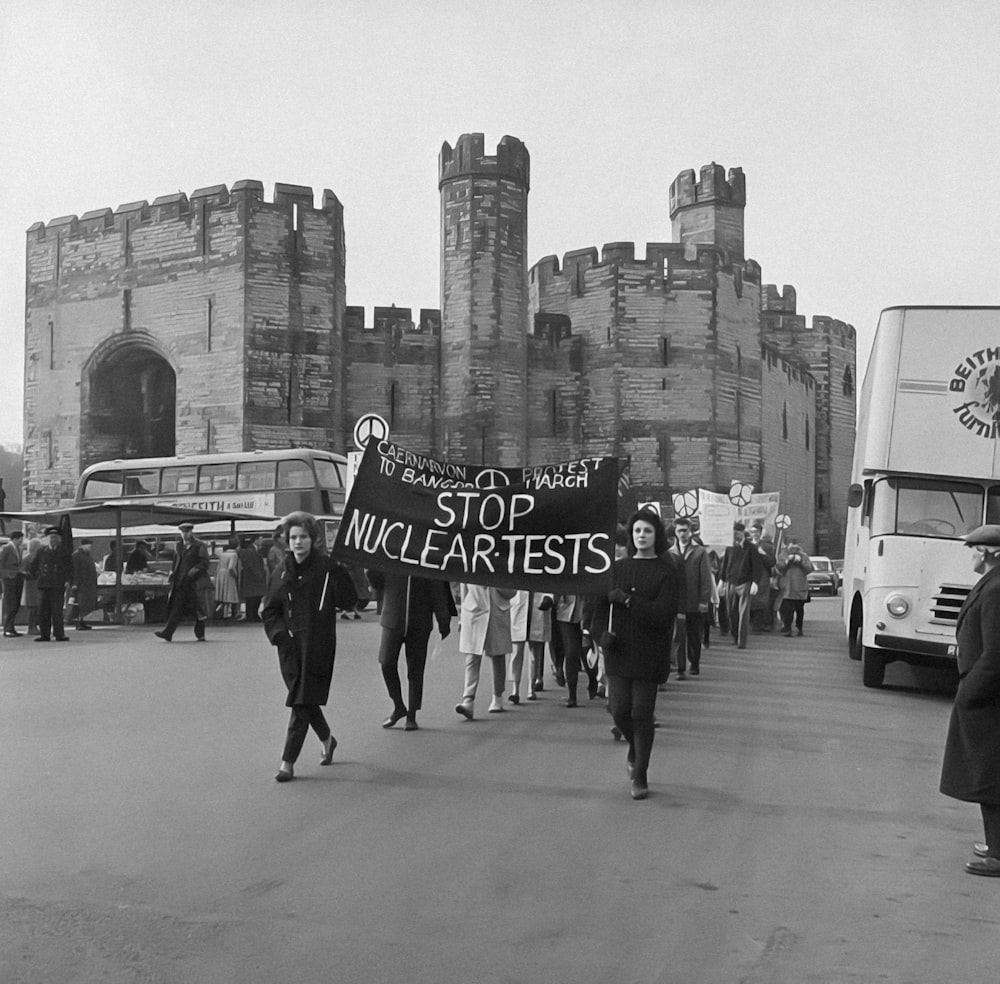 a group of people walking down a street holding a sign
