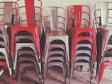 Stack of colorful school chairs arranged neatly in classroom.