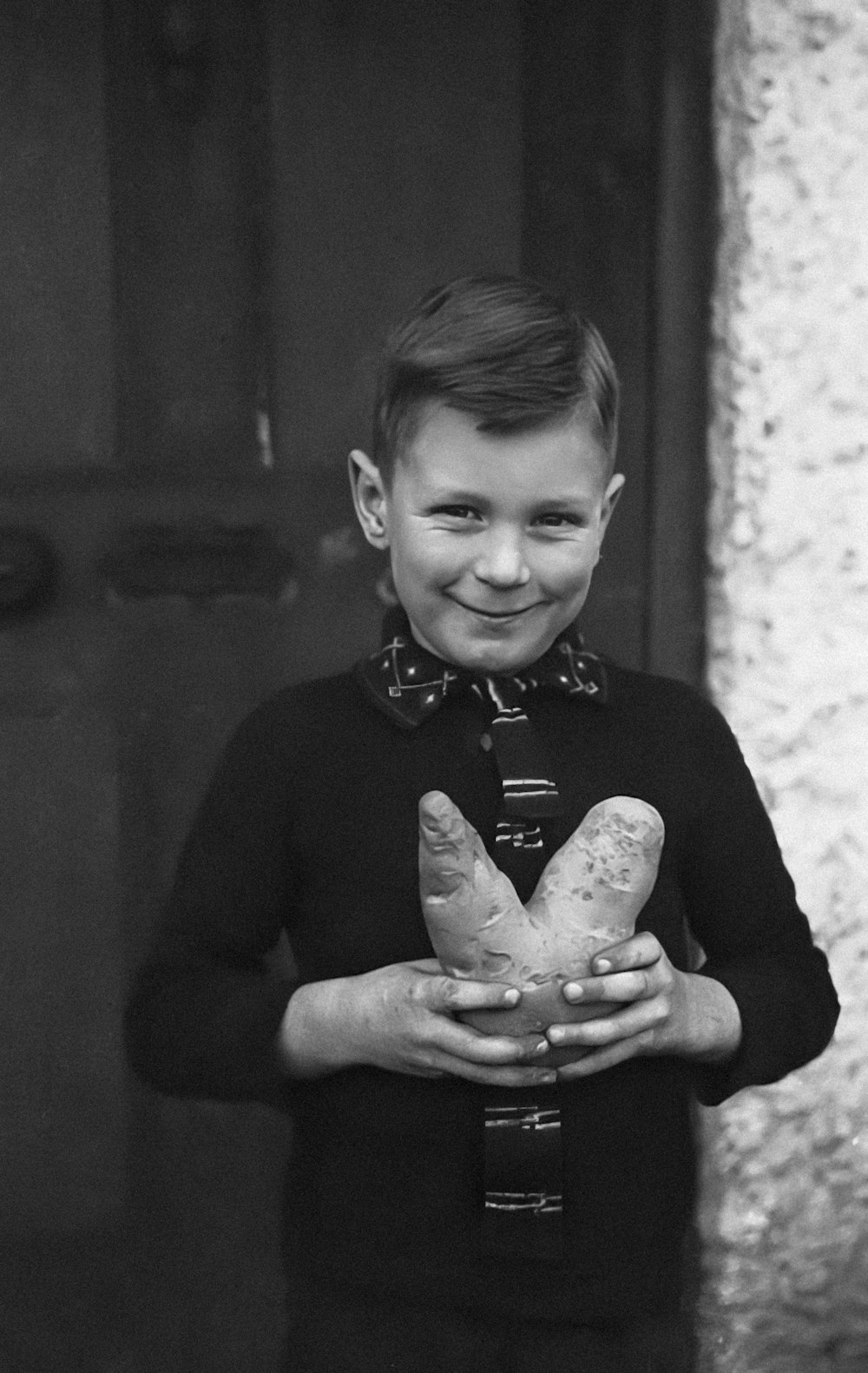 a young boy holding a loaf of bread
