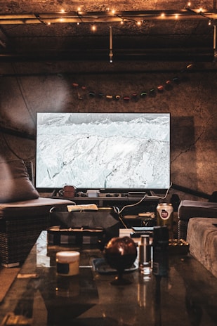 Interior of a cozy living room with cable TV playing in the background.