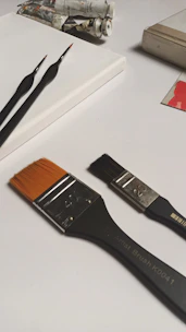 Paintbrushes, colorful paints, and blank canvases set up for a painting craft kit.