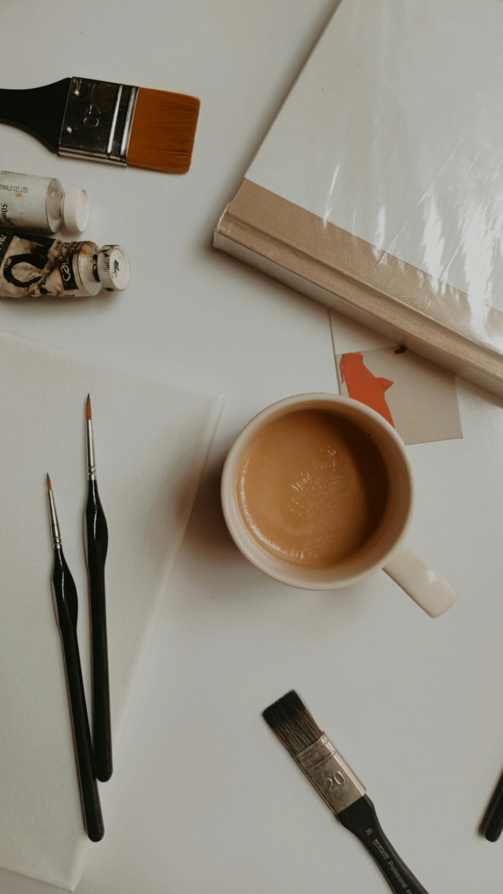 a cup of coffee sitting on top of a white table