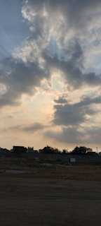 Sunlight breaking through clouds over a calm landscape, symbolizing hope and divine guidance.