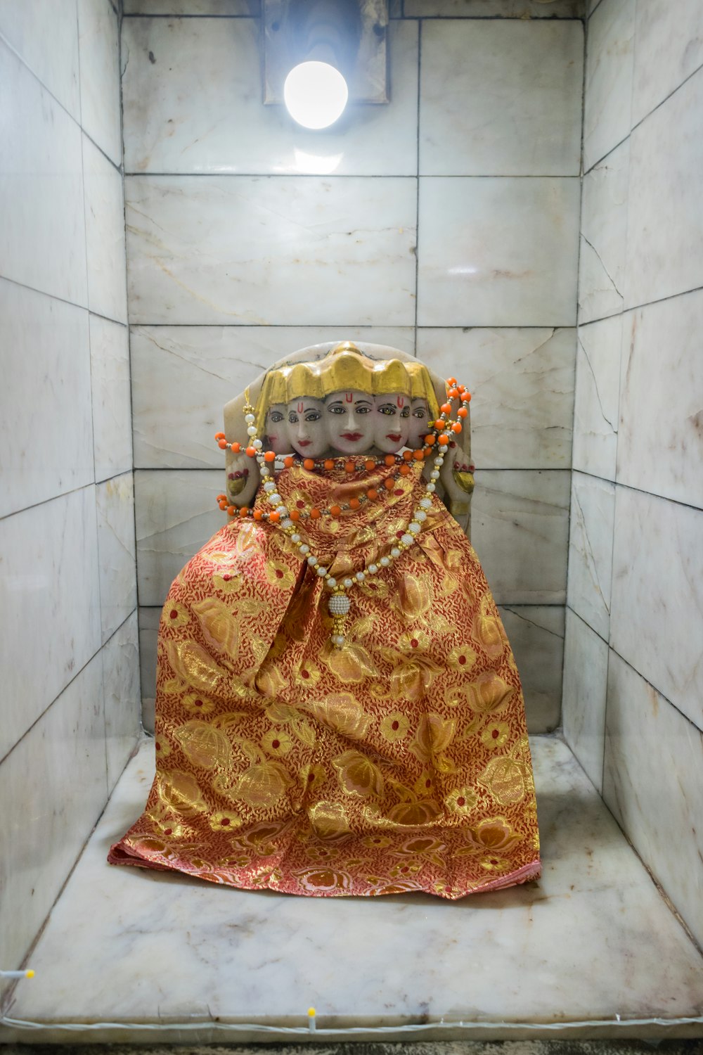 Una estatua de una mujer con un traje dorado y naranja