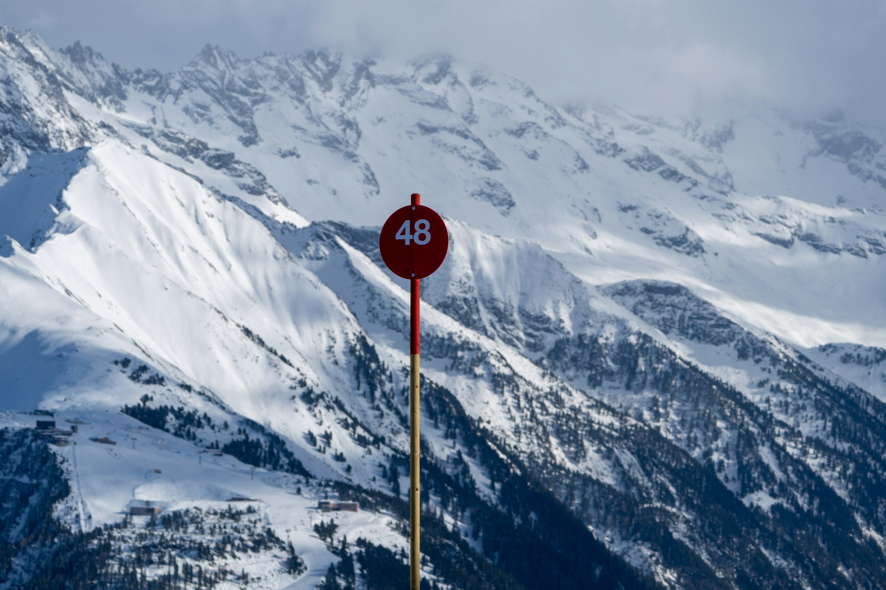 ein rotes Schild an der Seite eines schneebedeckten Berges