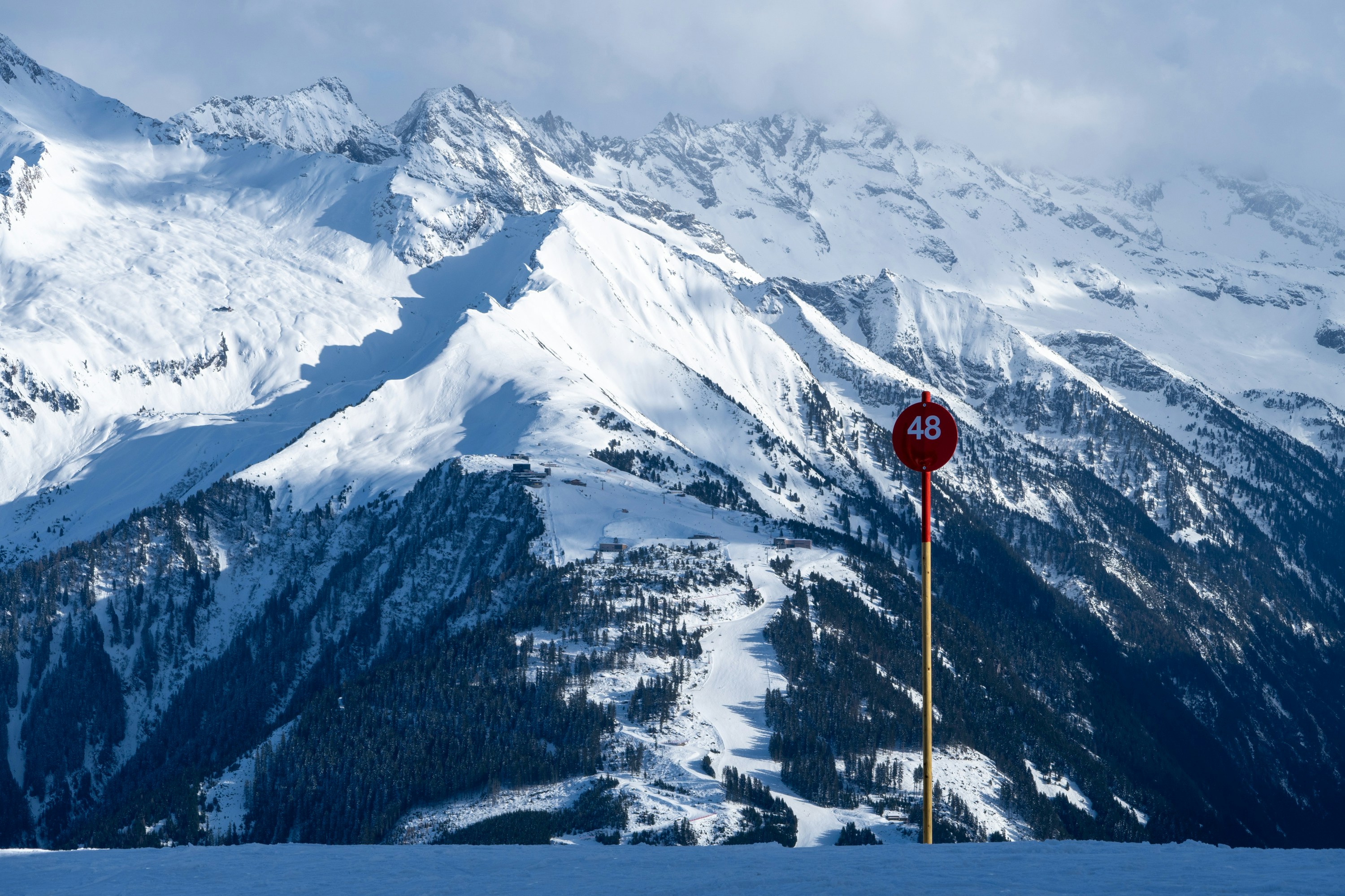 Ein rotes Stoppschild sitzt an der Seite eines schneebedeckten Berges