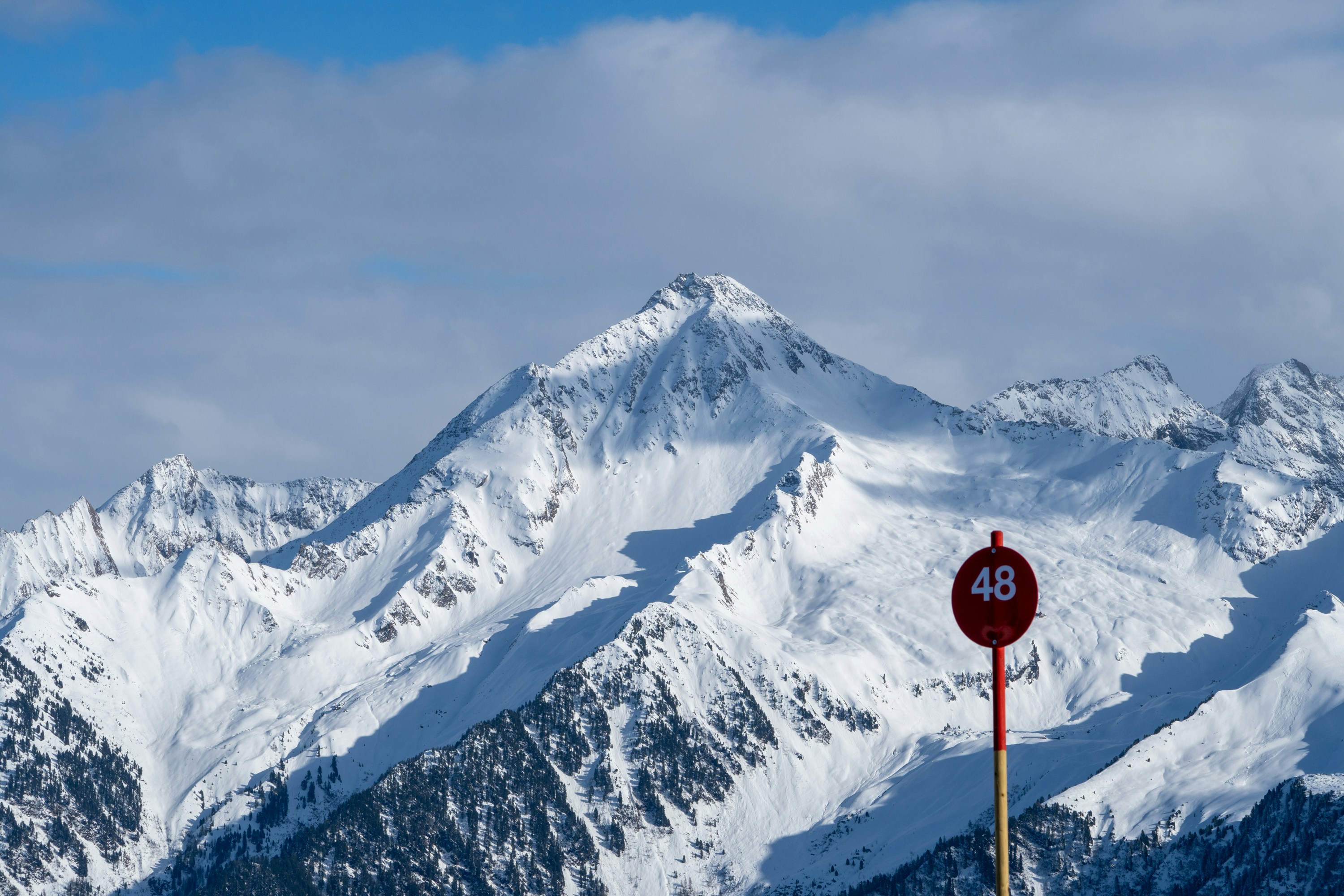 ein rotes Straßenschild an der Seite eines schneebedeckten Berges
