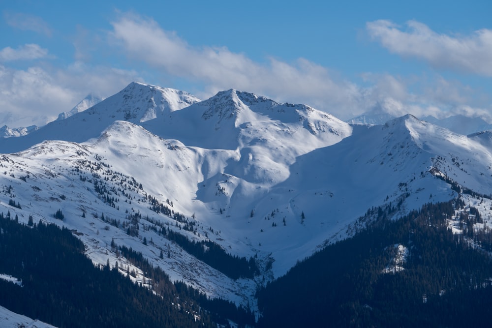 a mountain range covered in snow under a blue sky