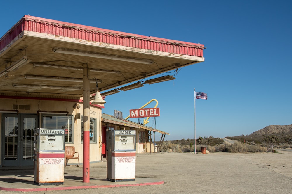 Une vieille station-service avec un drapeau flottant en arrière-plan