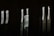 The image features a dark background with blurry, vertically elongated white letters spelling out 'HOSTEL'. The letters appear to be on an illuminated sign, but due to the blur, they are distorted and stretched.