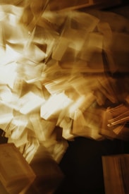 A chaotic swirl of blurred pages, creating an impression of dynamic movement and energy. The image has a warm, sepia-toned color palette, giving it a vintage feel.