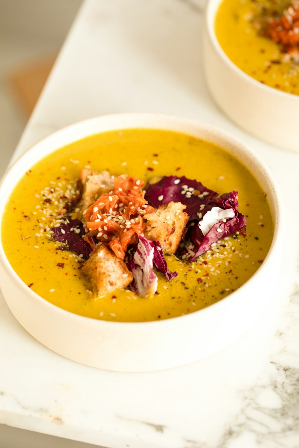 two bowls of soup are on a table