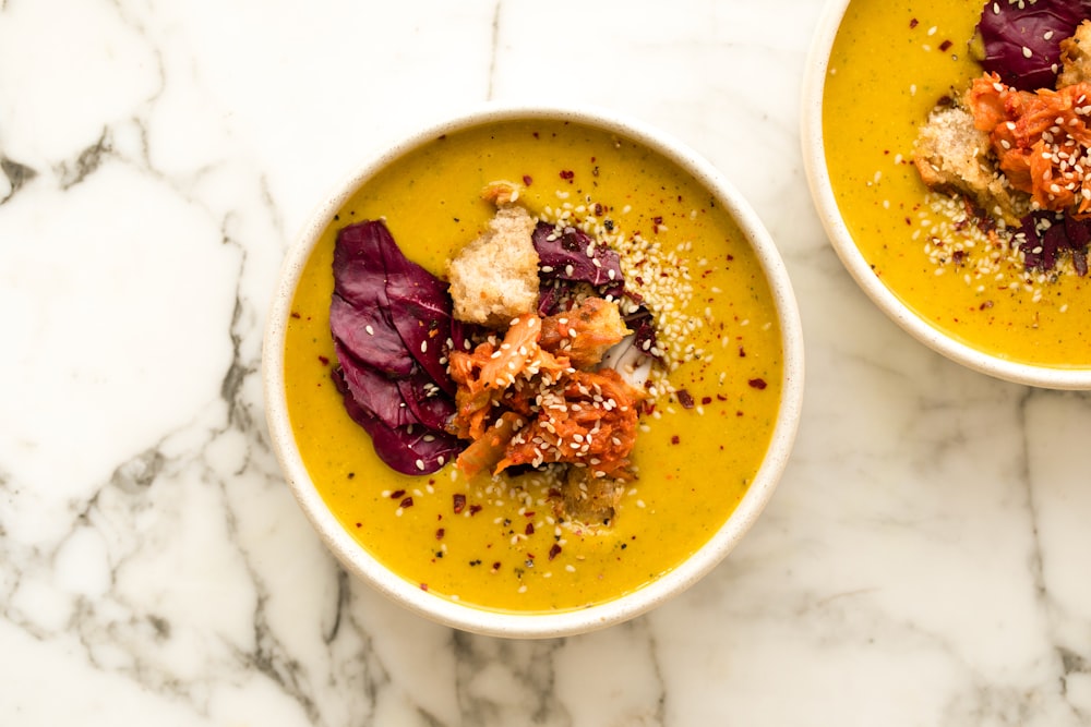 two bowls of soup on a marble table