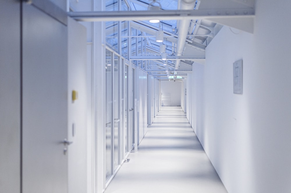 a long hallway with white walls and a skylight