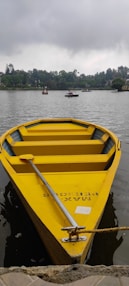 a small yellow boat floating on top of a lake