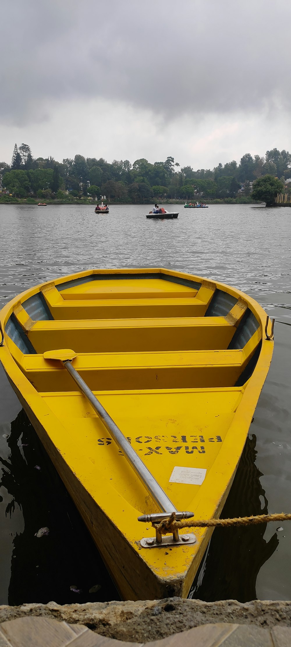 Un petit bateau jaune flottant au-dessus d’un lac