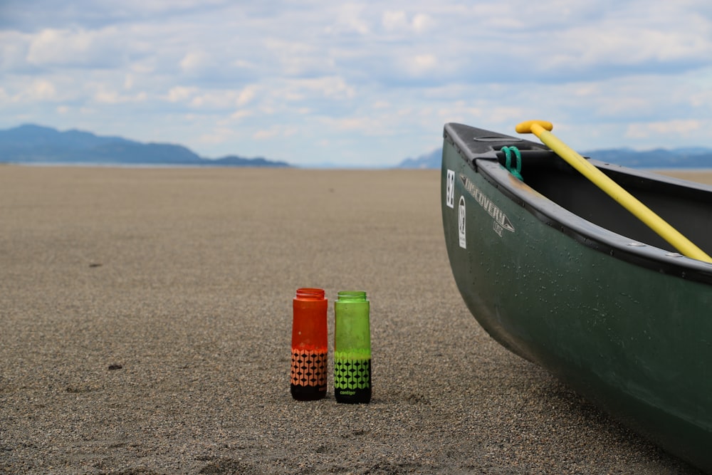 a row boat and two markers on the sand