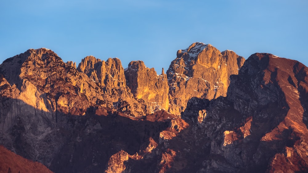 a mountain range with a blue sky in the background