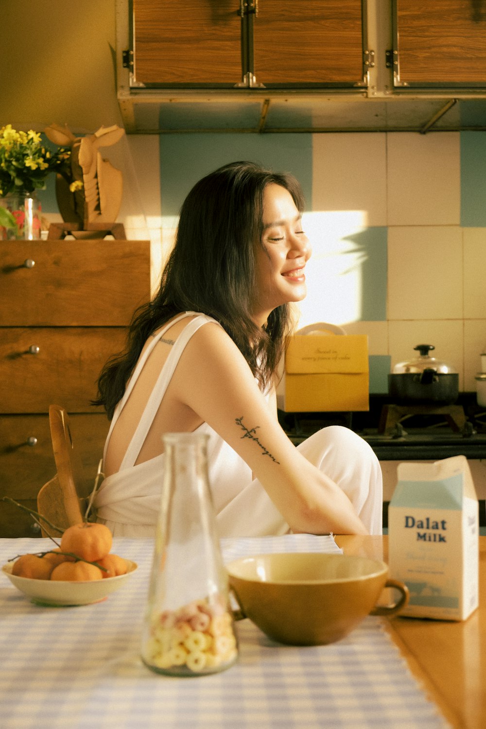 a woman sitting on a counter in a kitchen