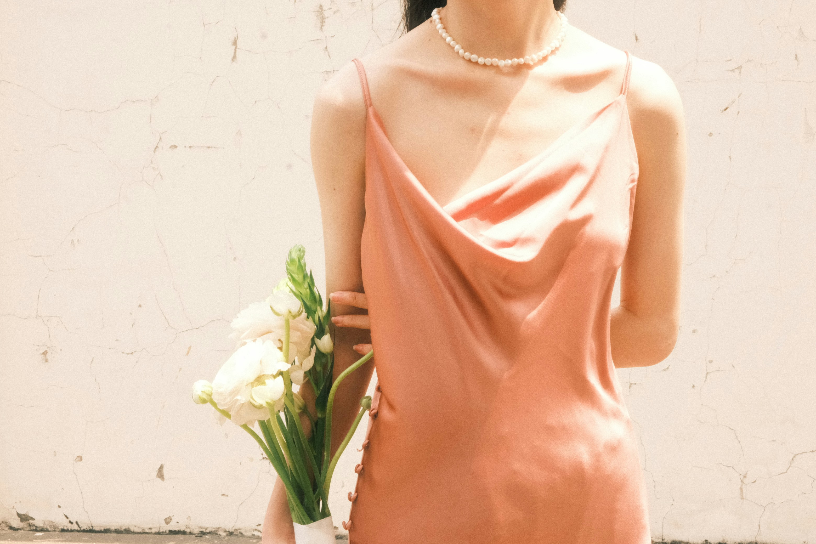 a woman in a pink dress holding a bouquet of flowers