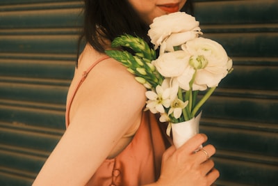 a woman holding a bouquet of white flowers