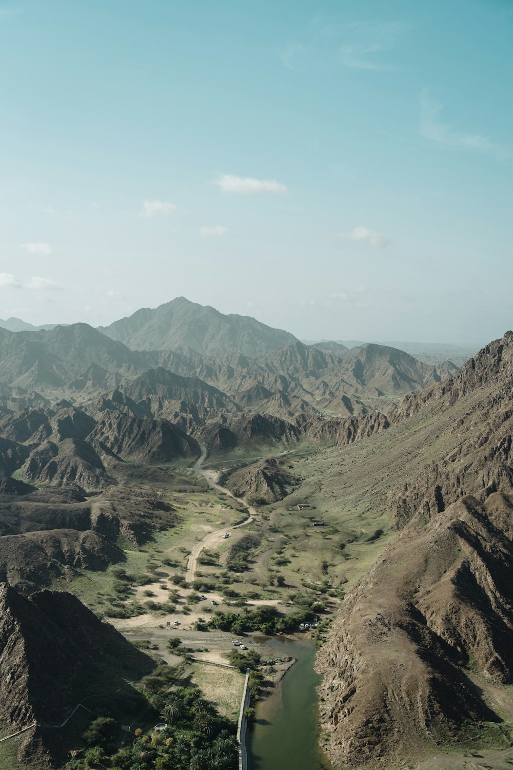 a river running through a valley surrounded by mountains