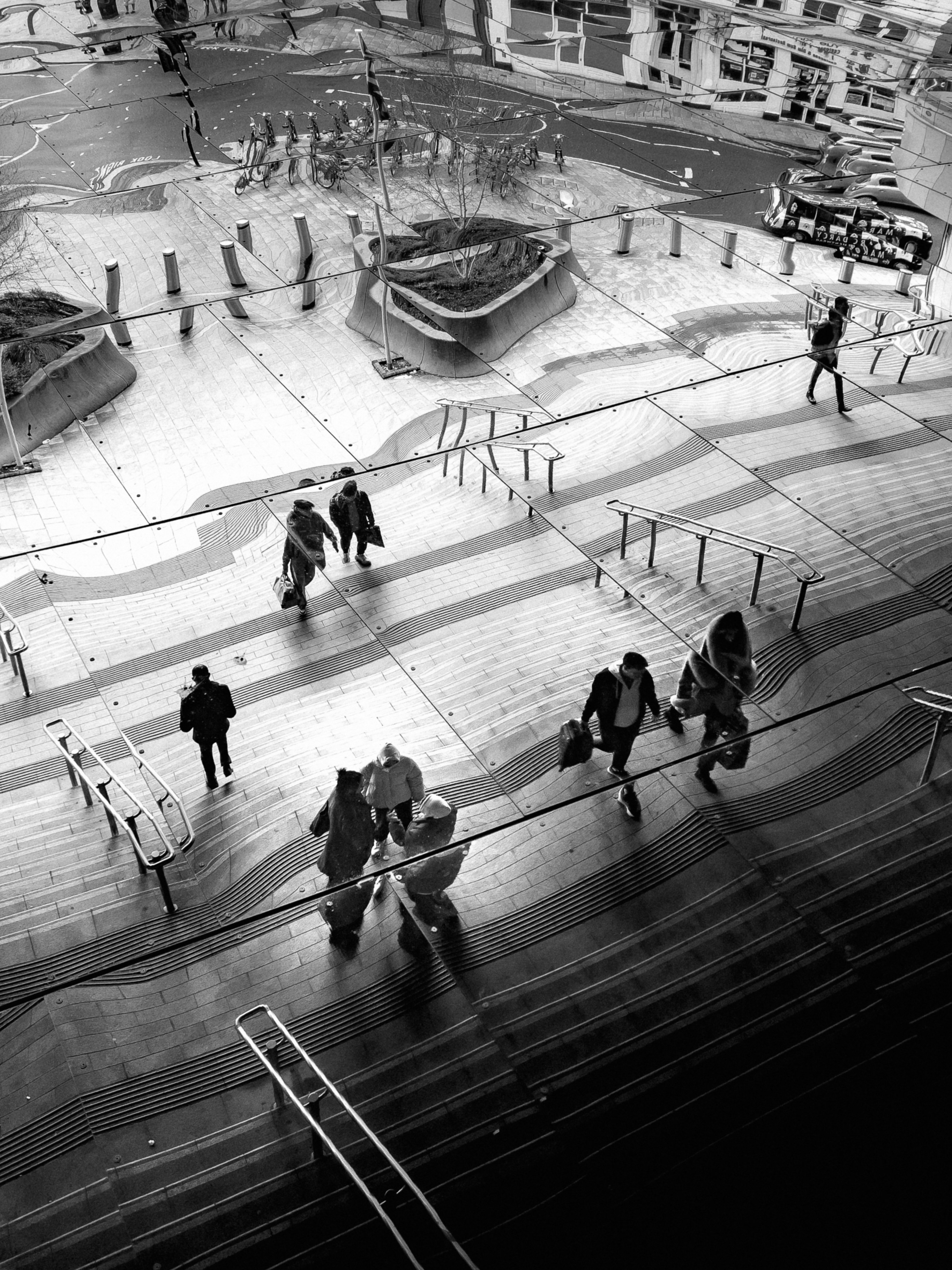 a black and white photo of people walking up stairs
