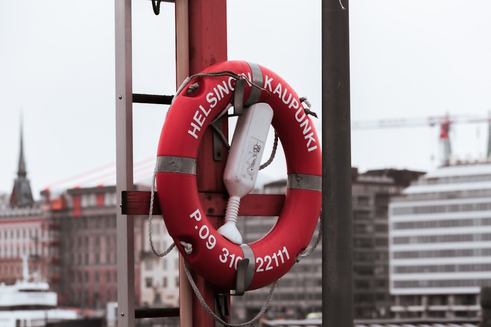 a life preserver attached to a pole with a city in the background
