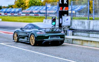Sleek race car wheels spinning fast on a track under bright sunlight.