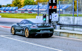 Sleek race car wheels spinning fast on a track under bright sunlight.