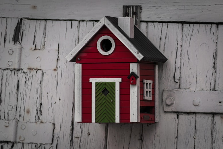 a red bird house with a green door