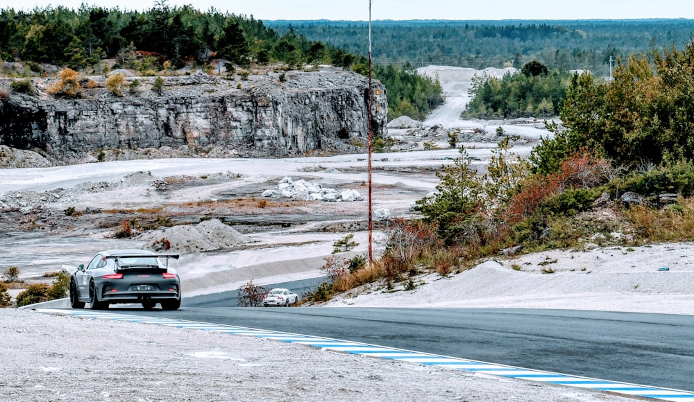 a car driving on a road near a mountain