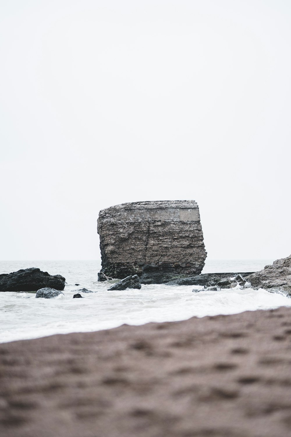 Ein großer Felsen, der aus dem Ozean ragt
