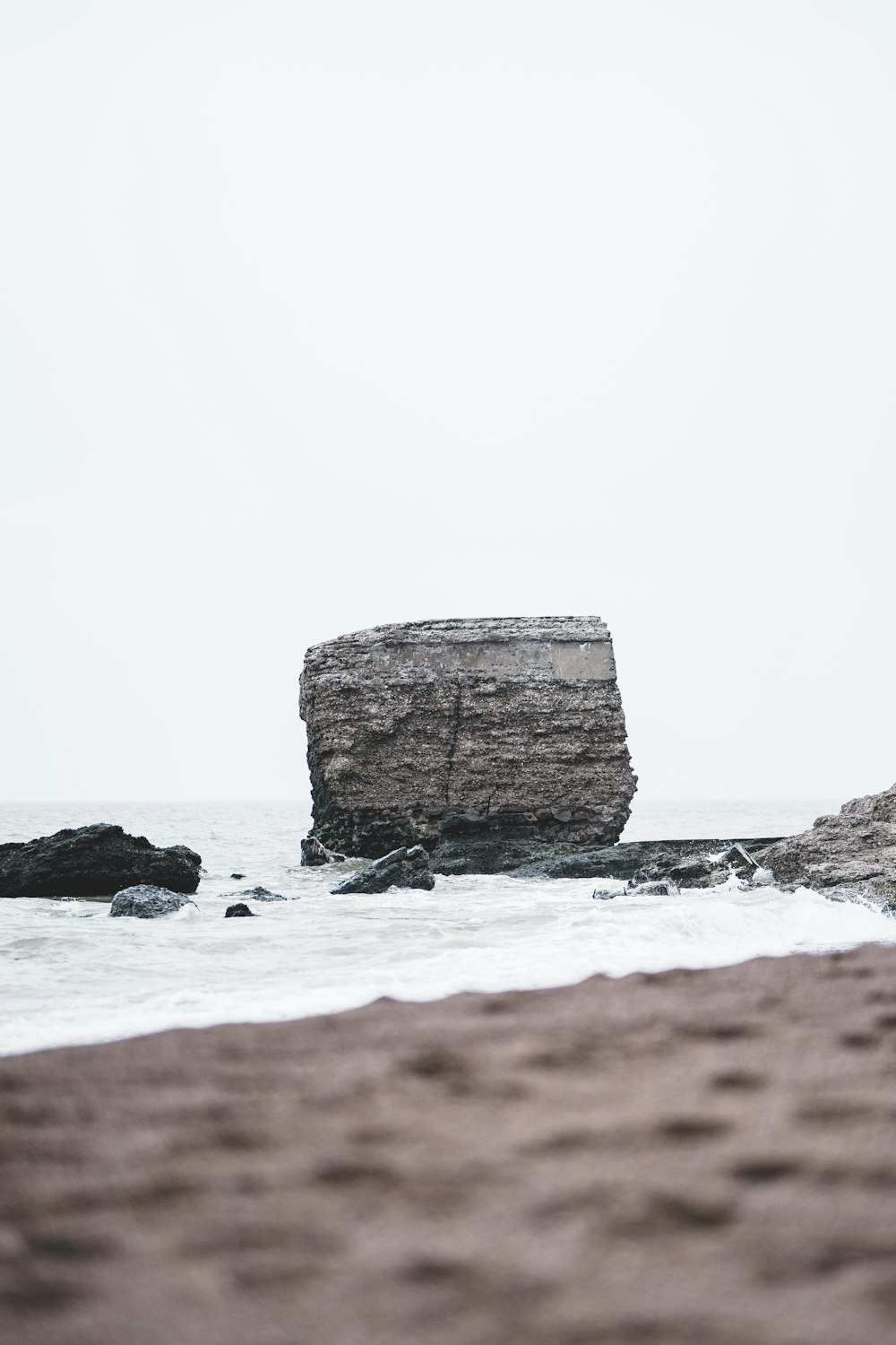 a large rock sticking out of the ocean