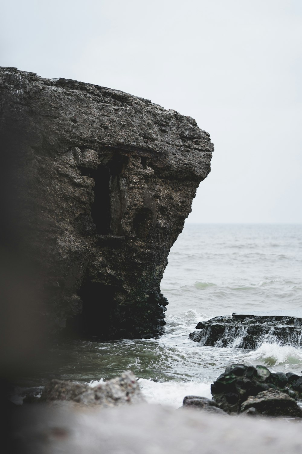 a man standing on top of a cliff next to the ocean