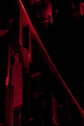 Dark architectural elements are lit by red lights, creating a dramatic and mysterious atmosphere. The structures feature intricate patterns and shapes, with strong contrasts of light and shadow.