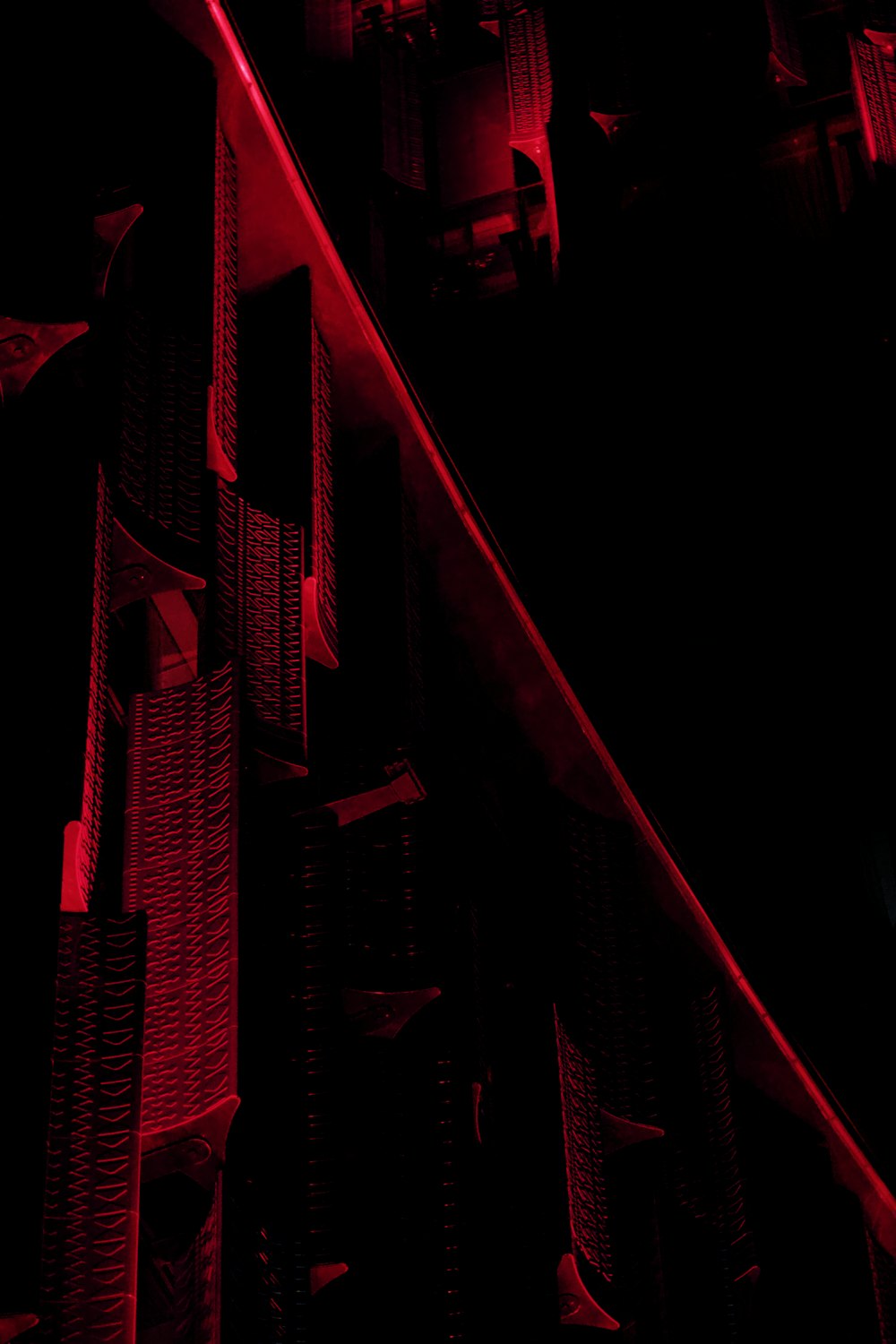 a red light shines on the side of a building