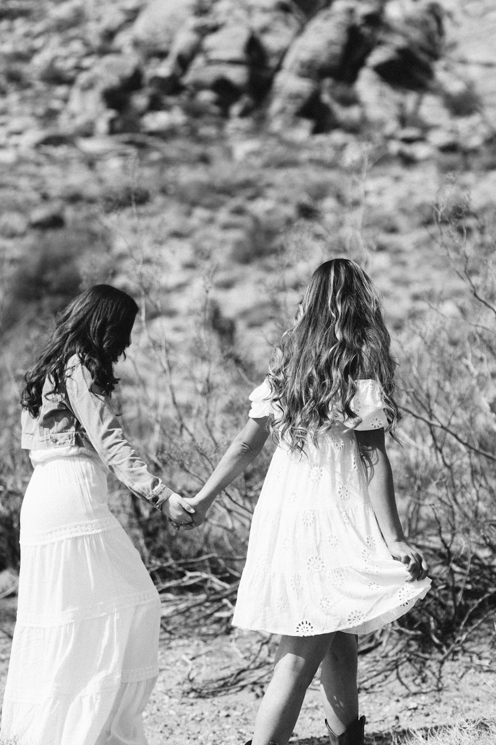 two little girls holding hands in the desert
