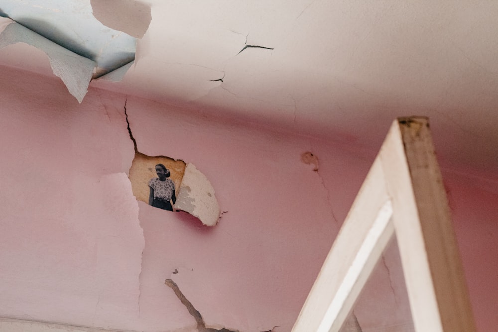 a hole in the ceiling of a pink room