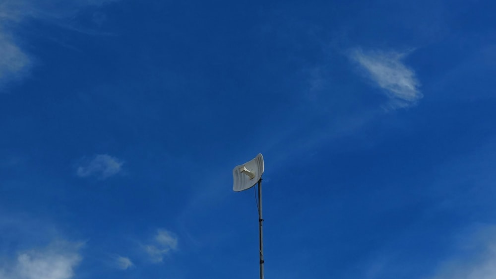a satellite dish on top of a metal pole