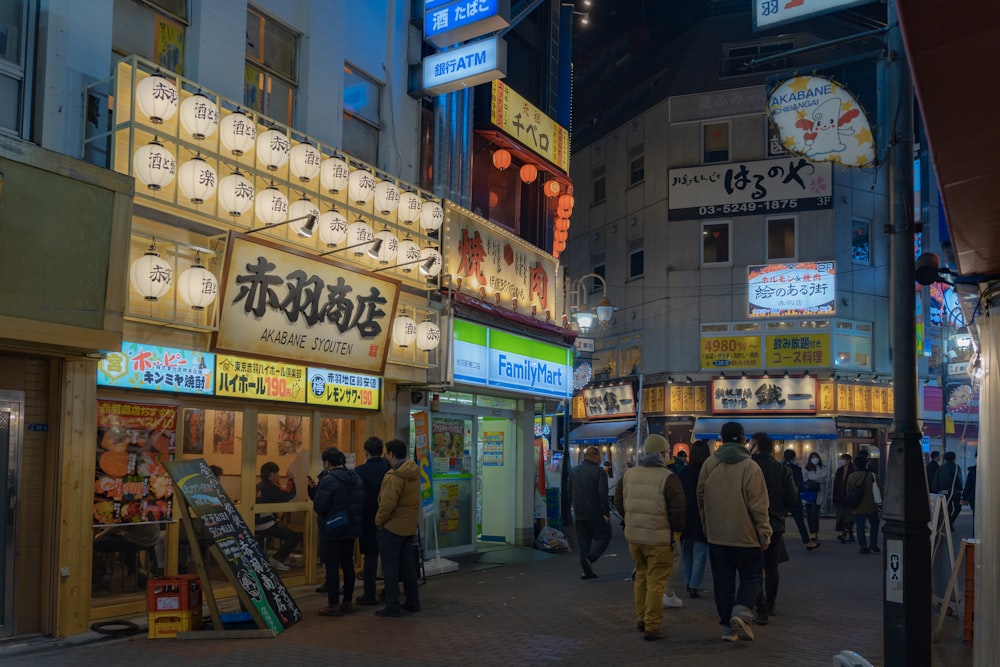 a group of people walking down a street next to tall buildings