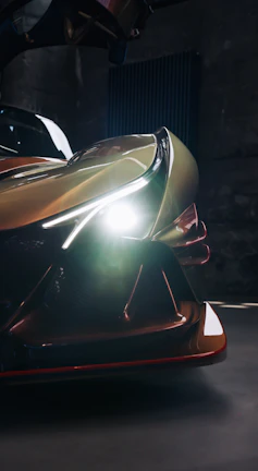 Close-up of a futuristic vehicle prototype with glowing lines under soft lighting.