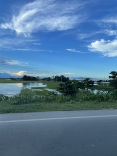 A serene landscape with a blue sky and green fields.