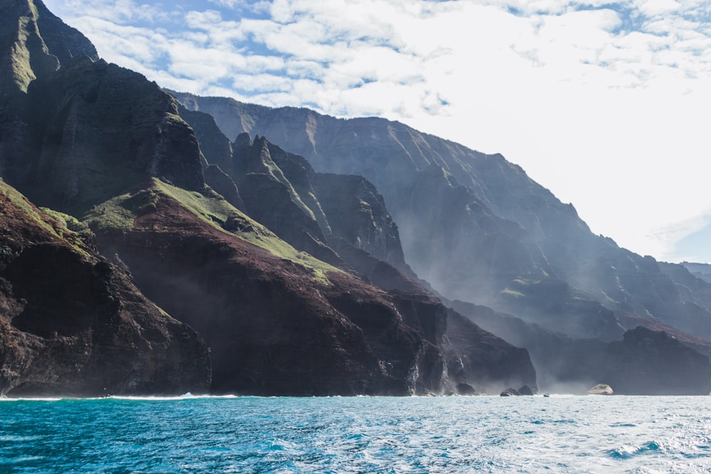 a boat is in the water near a mountain